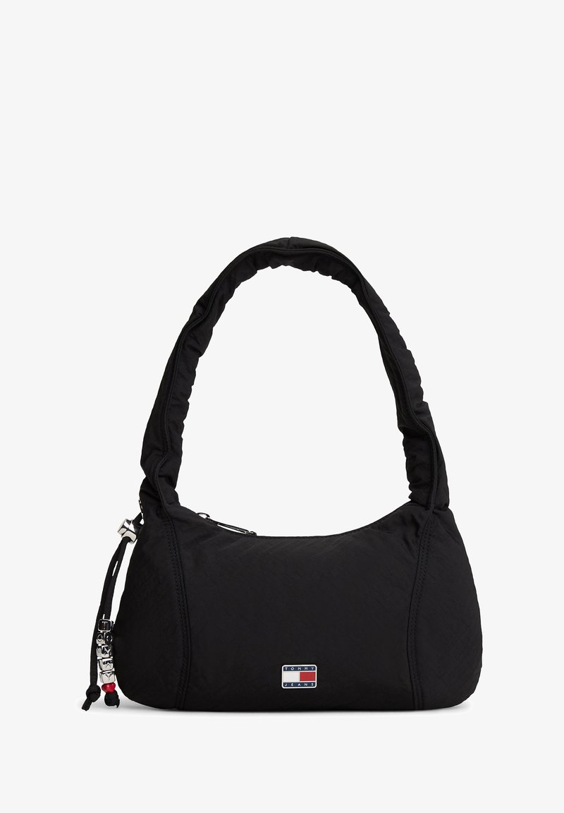 Czarna nylonowa torba na ramię z miękkim, wyściełanym paskiem, zamkiem błyskawicznym, naszywką z logo oraz ozdobnymi akcentami ze sznurka. Gładka faktura i zaokrąglony kształt.