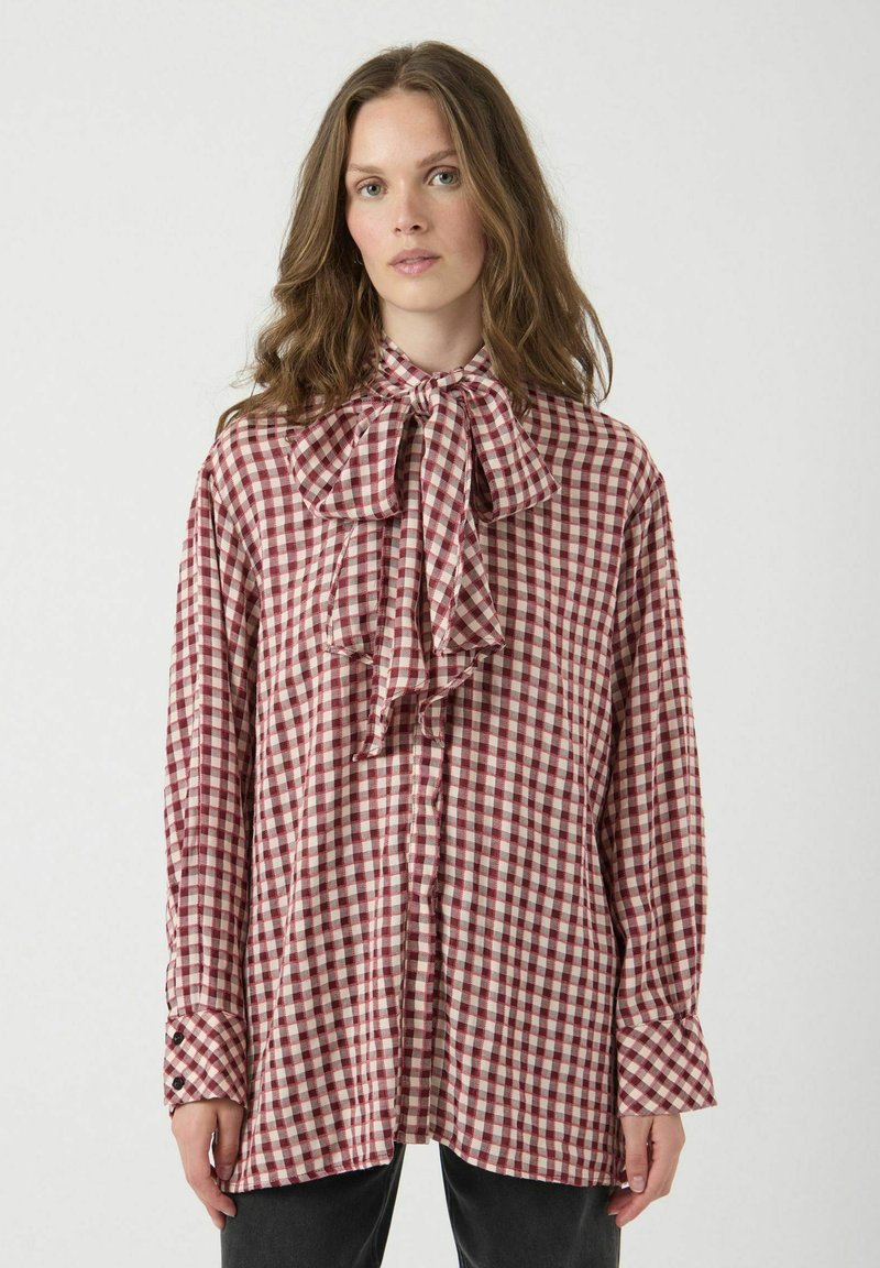 Rood-wit geruite blouse met een grote strik bij de kraag, lange mouwen en knoopmanchetten. Lichtgewicht stof met een losse pasvorm.