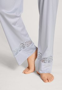 Lichtblauwe pyjamabroek met kantafwerking aan de zoom, gemaakt van een zachte stof en met een losse pasvorm. Zorg voor comfort tijdens het dragen met een relaxte silhoutte.