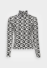 Långärmad polotröja, svart och vit, med ett mönster av hjärtan inom ett rutnät. Tillverkad av mjukt tyg med en figurnära passform.