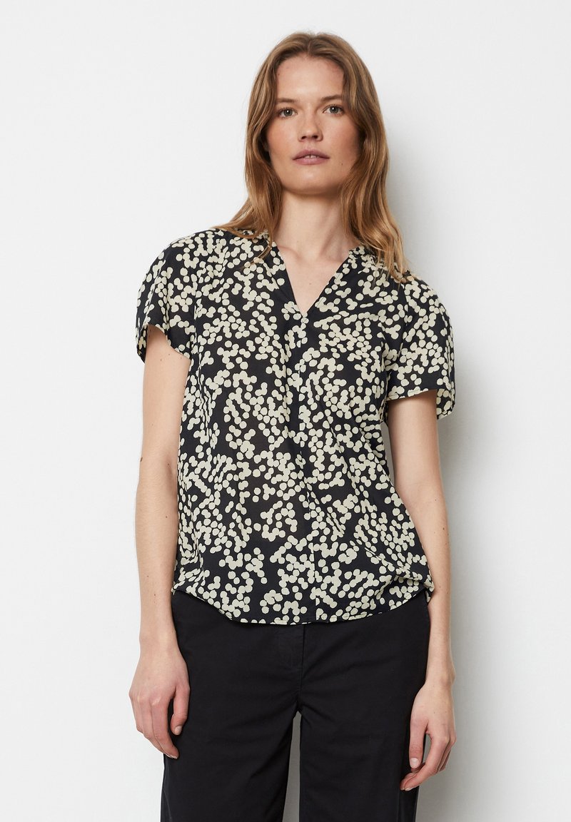 Kurzärmlige schwarze Bluse mit weißem Blumenmuster, V-Ausschnitt, leichtem Stoff und leicht abgerundetem Saum.