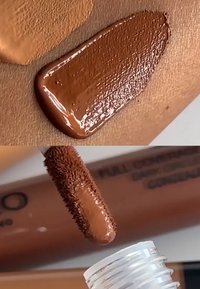 Échantillon de liquide marron sur la peau, texture lisse. Gros plan sur une baguette avec des poils denses, mettant en avant un produit marron assorti dans un tube transparent.