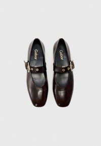 Chaussures Mary Jane en cuir brun foncé avec un bout carré, dotées d'une lanière et d'une boucle ronde, surface texturée et doublure intérieure lisse.