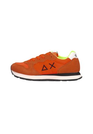 Orange-brauner Sneaker mit schwarzer Sohle, Schnürsenkeln, schwarzen geometrischen Symbolen an der Seite und einem weißen Fersenlaschen mit schwarzen Zahlen.