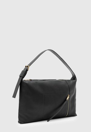 Čierna kožená kabelka na rameno s nastaviteľným popruhom, zlatou prackou a diagonálnou zipsovou kapsou vpredu na jednoduchom svetlosivom pozadí.