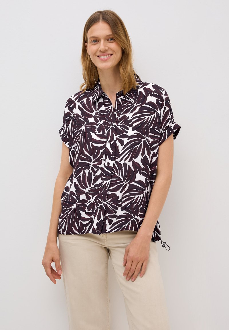 Chemise à manches courtes blanche avec un motif de feuilles violet foncé, dotée d'un devant à boutons et d'une coupe décontractée.