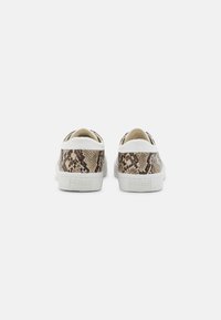 Brown and beige snake-print sneakers with white rubber soles and heel accents, featuring a textured upper and branding on the heel.