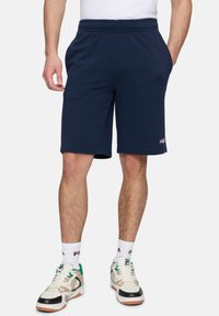 Navyblauwe sweatshorts van zachte stof, met een elastische tailleband en zijzakken, met een klein wit logo-detail op het been.
