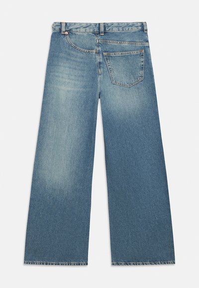 Φαρδιά τζιν παντελόνια ανοιχτού γαλάζιου χρώματος από denim, με ψηλή μέση, πίσω τσέπη και φθαρμένες άκρες στο τελείωμα.