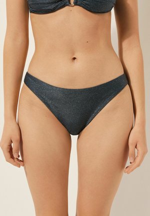 Bas de bikini bleu foncé avec une texture lisse, coupe taille basse et fines bretelles latérales. Le tissu présente un léger éclat, mettant en valeur son design élégant.