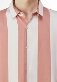 Camicia a maniche corte con righe verticali rosa e bianche, colletto a punta e chiusura con bottoni, realizzata in tessuto morbido.