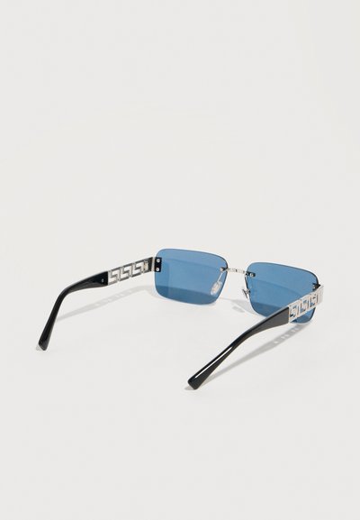 Μπλε ορθογώνια γυαλιά ηλίου χωρίς σκελετό με ασημένια γεωμετρικά μπράτσα και μαύρες άκρες στα κροτάφους σε λευκό φόντο.