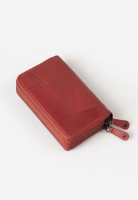 Rode leren portemonnee met een gladde textuur, rits rondom, contrasterende stiksels en dubbele ritstrekkers. Eenvoudig rechthoekig ontwerp.