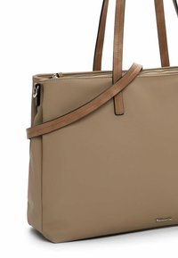 Borsa a tote sintetica beige con due manici e una tracolla rimovibile più lunga. Presenta una chiusura superiore con zip e un sottile accento del logo sul davanti.