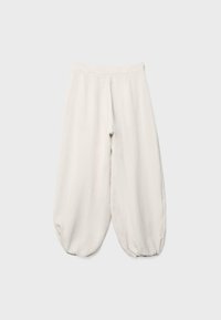 Pantalon blanc ample avec jambes bouffantes resserrées aux chevilles, équipé d'une ceinture simple sans fermetures visibles.
