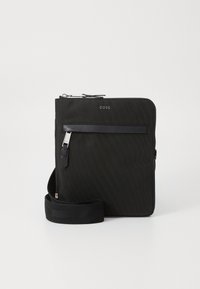Schwarze Nylon-Crossbody-Tasche mit strukturierter Oberfläche, Reißverschluss, Vordertasche und verstellbarem Tragegurt. Hat dezente Branding-Elemente auf der Vorderseite.