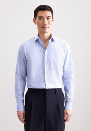 Camicia azzurro chiaro con un piccolo motivo geometrico, maniche lunghe, colletto alla francese e una texture liscia, indossata con pantaloni blu navy.