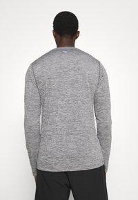 Langärmliges Hemd aus grauem Melange-Stoff mit rundem Hals und glatter Textur; mit kleinem Logo auf dem oberen Rücken.