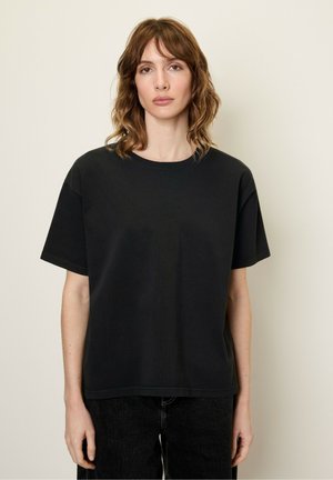 Zwarte t-shirt met korte mouwen van zachte stof, met een ronde hals en een ontspannen pasvorm, gecombineerd met donkere jeans.