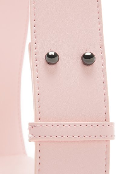 Sangle en faux cuir rose clair avec des clous noirs et des détails de couture, présentant une forme élégante et une texture lisse.