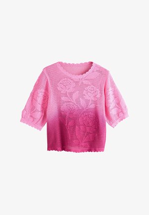Haut rose en maille crochet à manches courtes avec bords festonnés et motifs floraux en relief sur le devant et les manches.