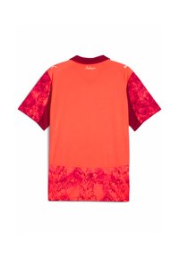 Camisa de rugby de manga corta en un naranja brillante con acentos en rojo oscuro. Presenta un patrón floral en la parte inferior y en los hombros. Textura de tela suave.