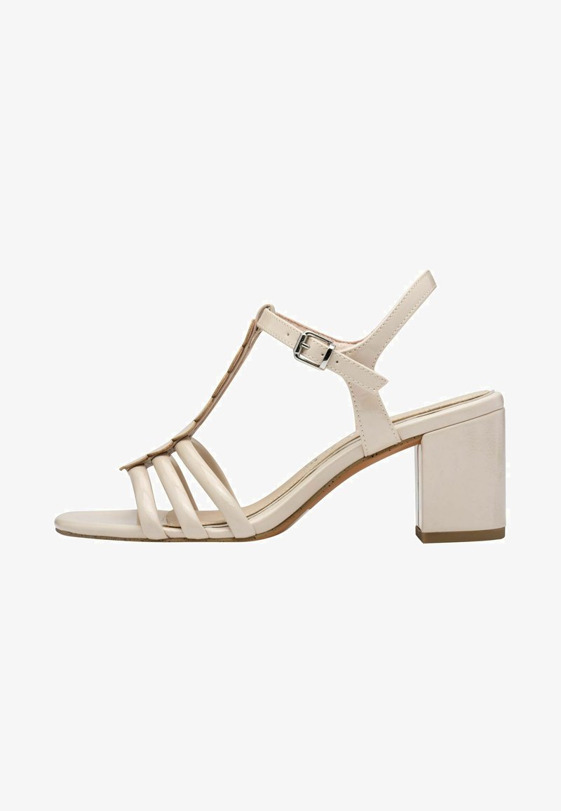 Sandales à talon beiges avec un design en T, de multiples lanières, un bout carré et un talon bloc. Fabriquées en matériau synthétique lisse.