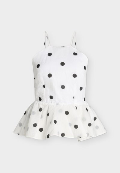 Top blanc sans manches avec des pois noirs et un ourlet peplum évasé, avec de fines bretelles.