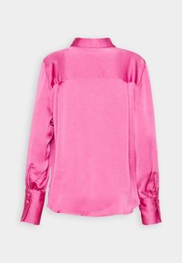 Blouse en satin à manches longues de couleur rose vif, vue de dos, avec un col classique et des poignets boutonnés.