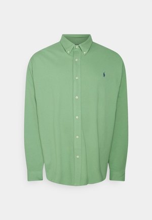 Chemise vert clair à manches longues avec boutons, col boutonné et petit logo sombre sur la poitrine gauche.