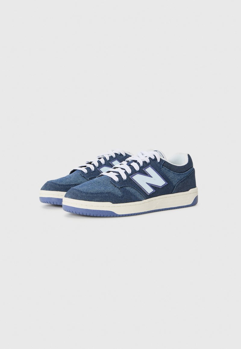 Navy denim sneakers featuring white laces, a light blue logo, and a cream midsole with a textured rubber outsole.