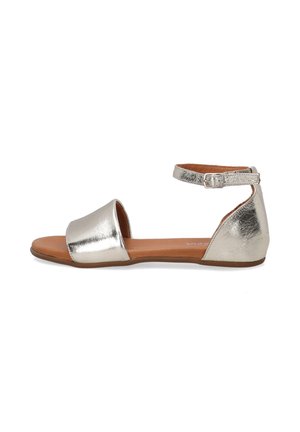 Metallic silver flat sandals with ankle strap, open toe design, smooth texture, brown footbed, and minimalistic style.