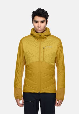 Gelbe isolierte Jacke mit einem geometrischen Steppmuster, ausgestattet mit einer Kapuze, Frontreißverschluss und kontrastierenden Ärmeln. Logo auf der Brust sichtbar.