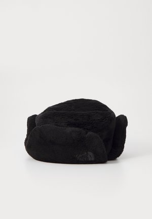 Svart pushet lue med øreflapper, rund krone, myk tekstur, med en liten logo på siden. Passer for kaldt vær.