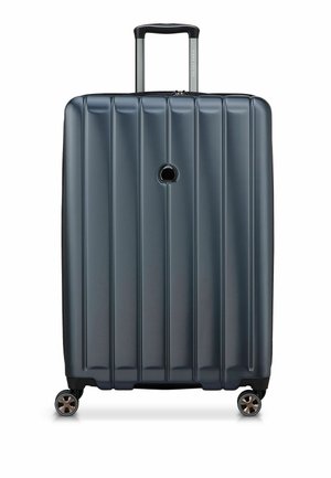 Valigia rigida di colore blu scuro con design a righe verticali, manico retrattile e quattro ruote girevoli per una facile manovrabilità.