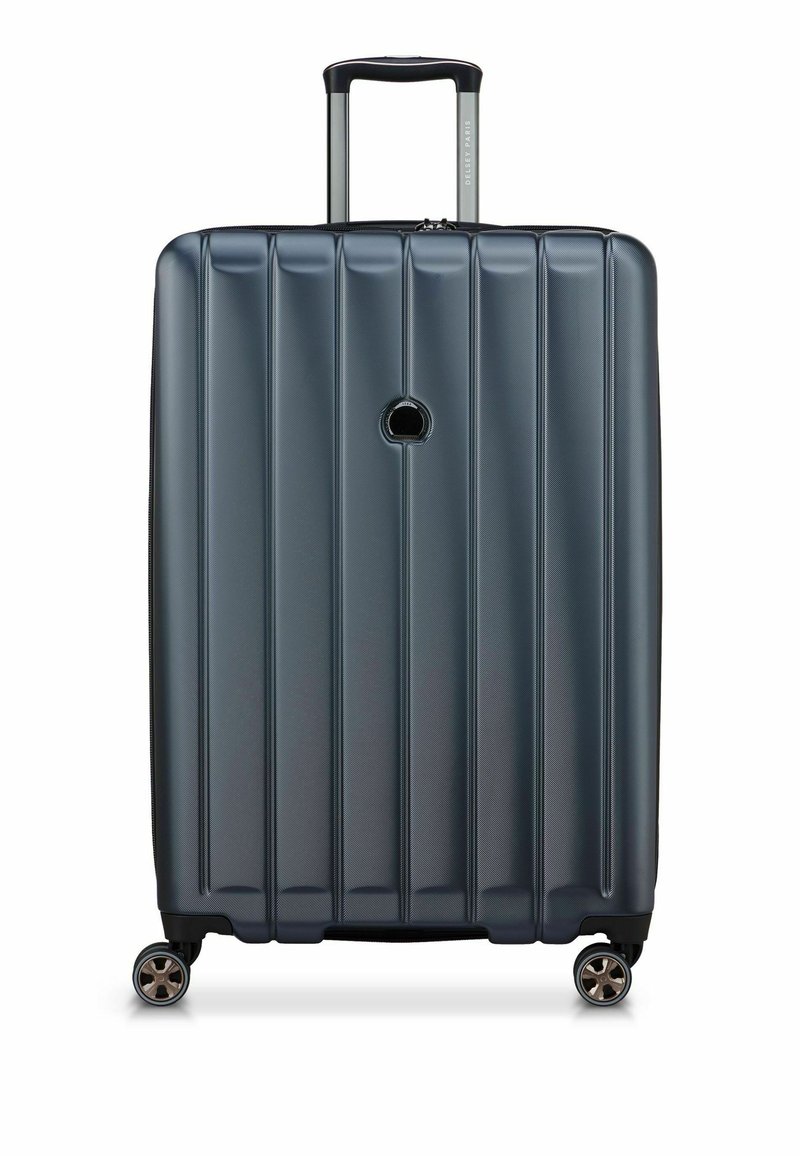 Harde koffer in donkerblauw met verticale ribbelontwerp, uitschuifbare handgreep en vier draaibare wielen voor eenvoudige wendbaarheid.