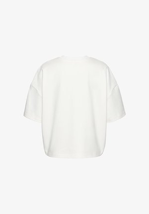 Fehér, oversized, rövid ujjú póló hátulról, kerek nyakkivágással és lehajtott vállvarrással.