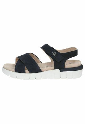Navy blue suede sandal with two cross straps, adjustable ankle strap, and a white cushioned outsole with ridges for traction.