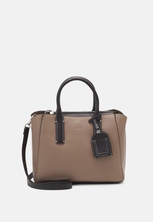 Torebka w kolorze taupe z czarnymi rączkami, odpinanym paskiem na ramię, zamkiem błyskawicznym na górze oraz czarną zawieszką bagażową z białym przeszyciem.