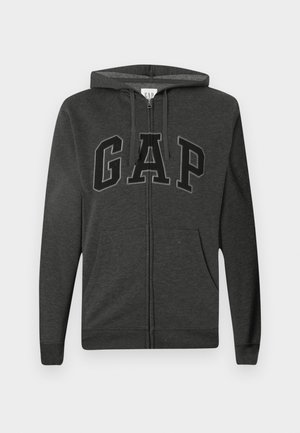 Dark gray zip-up hoodie with front pockets, adjustable drawstring hood, and large black outlined "GAP" letters across the chest.