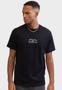 Μαύρο βαμβακερό μπλουζάκι με λευκό γραφικό κείμενο, στρογγυλή λαιμόκοψη, κοντά μανίκια και άνετη εφαρμογή. Ελαφριά υφή, καθημερινό στυλ.