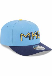 Blaue Kappe mit einem dunkelblauen Schirm, auf der Vorderseite mit gelber "MKE" Stickerei und kleinen Ösen an den Seiten zur Belüftung versehen.