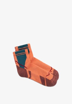 Pair of ankle-length socks in orange with brown toes and heels, featuring dark teal and red geometric patterns.