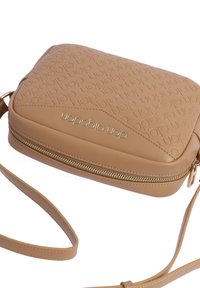 Bolso cruzado de cuero marrón con diseño de logotipo en relieve, cierre con cremallera y correa ajustable. Textura suave con acentos geométricos.