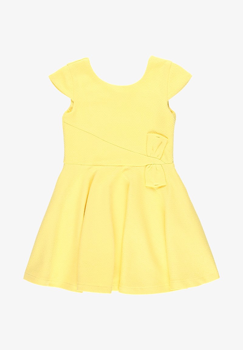 Żółta sukienka z krótkimi rękawami typu cap, fakturowana tkanina, sylwetka w kształcie litery A i detal w postaci kokardy z boku. Prosty okrągły dekolt i rozkloszowany dół.