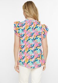 Bunte Bluse mit floralem Muster in Pink, Grün, Orange und Lila, mit puffärmel und gerafftem Ausschnitt.