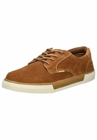 Braune Wildledersneaker mit strukturiertem Obermaterial, Schnürverschluss, kontrastierender weißer Gummisohle und subtilen gelben Akzenten an der Seite.
