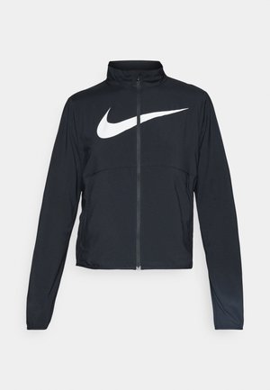 Veste de sport noire zippée sur toute la longueur avec un col haut, des manches longues et un grand logo Nike swoosh blanc sur la poitrine.