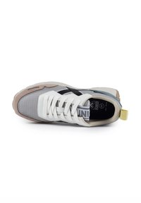 Sneaker with a gray and white mesh upper, black accents, and a beige sole. Features flat laces, branding on the tongue, and a yellow back tab.