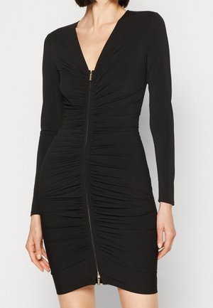 Czarna sukienka z długimi rękawami i głębokim dekoltem w serek. Materiał marszczony, z ozdobnym złotym zamkiem błyskawicznym z przodu.
